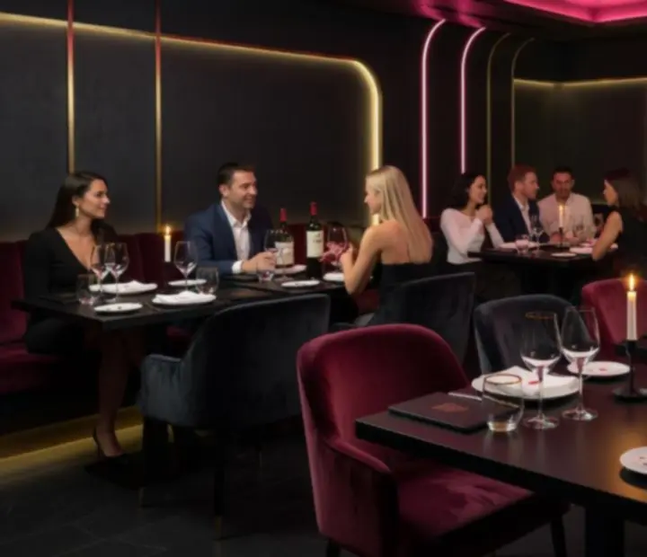 Atmospheric evening restaurant scene at NAXSOL ENTERPRISES LTD with softly lit casino-inspired dining tables.