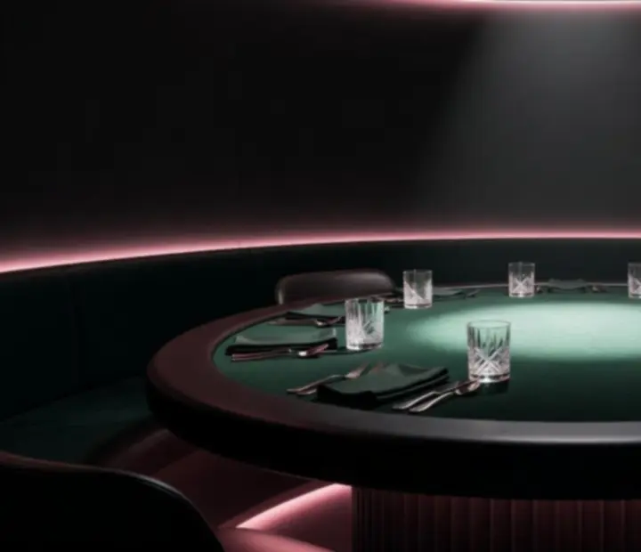 Evening table at NAXSOL ENTERPRISES LTD with matte-black surfaces, soft yellow candlelight, and pink accent details